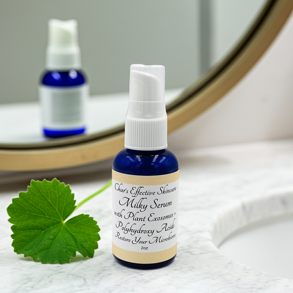 Skincare serum bottle with label, centella leaf, and mirror reflection on a textured surface.