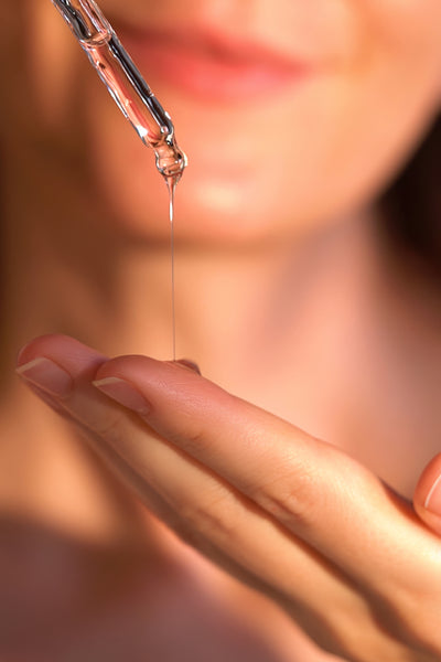 Dropper showing Drench & Quench Serum  dispensed onto finger